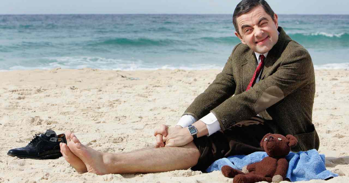 mr bean è sulla spiaggia col suo orsacchiotto e si tira su le zampe dei pantaloni: un'altra smorfia di rowan atkinson - nerdface