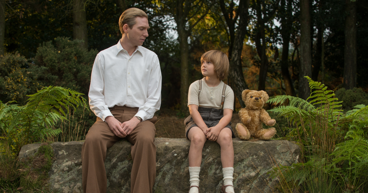 padre e figlio si guardano mentre sono seduti su un muretto in vi presento christopher robin - nerdface