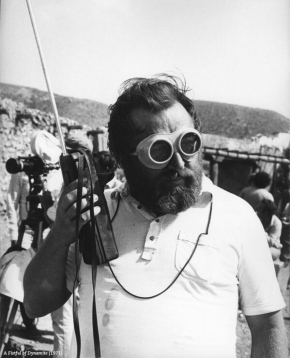 sergio leone ascolta qualcosa al walkjie talkie emntre indiossa un paio di occhiali enormi in mezzo al deserto - nerdface