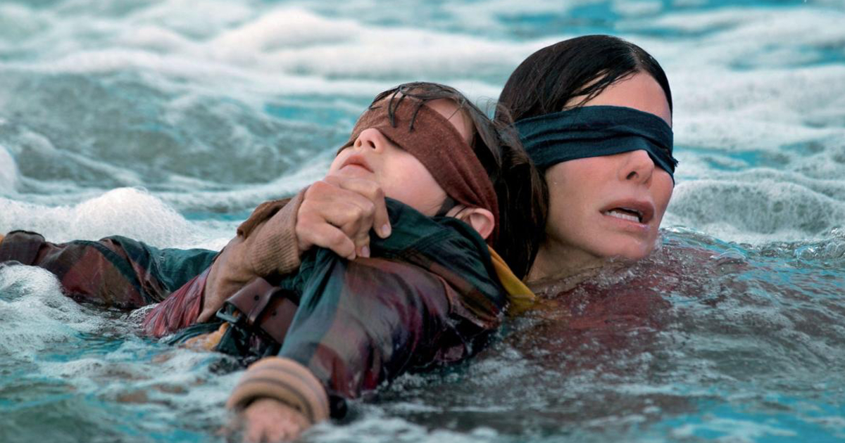 sandra bullock, bendata, tiene un bambino anch'esso bendato e cerca di guadare un fiume - nerdface