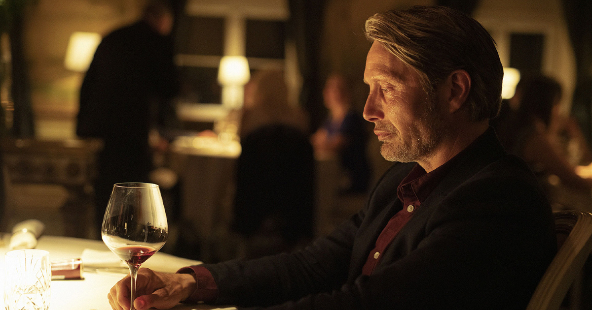 mads mikkelsen osserva una calice di vino bianco - nerdface