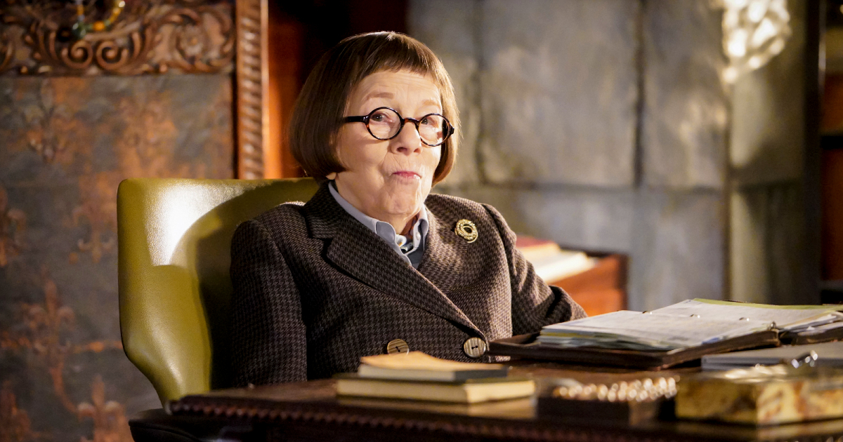 linda hunt seduta alla scrivania di ncis ghigna compiaciuta - nerdface