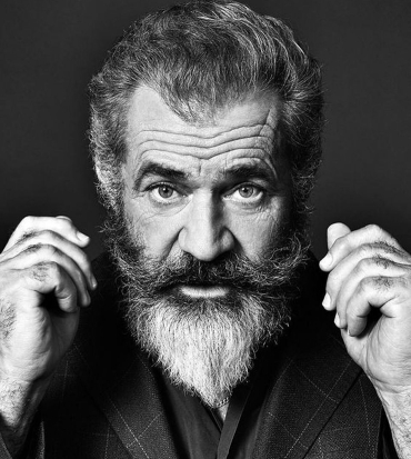 mel gibson in un ritratto in bianco e nero si alliscia i lunghi baffi - nerdface