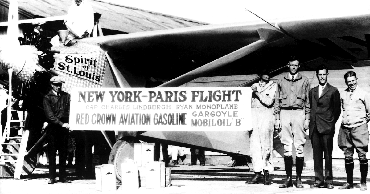 charles lindbergh e altri uomini tengono uno striscione con scritto volo new york parigi sott lo spirit di saint louis - nerdface