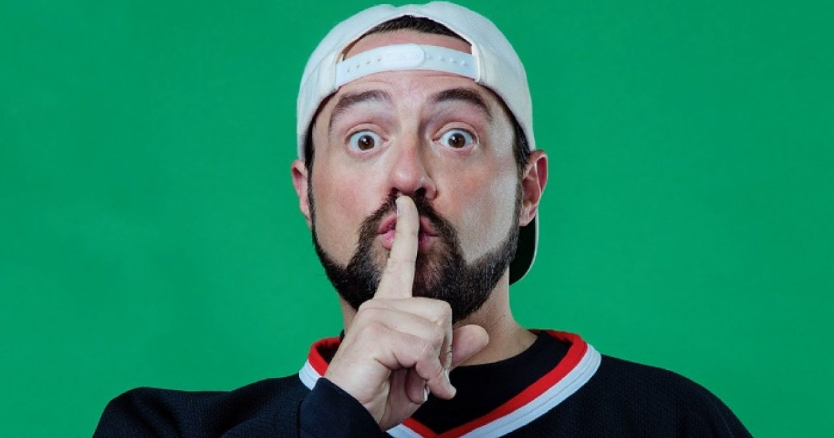 kevin smith col cappellino al contrario fa il segno del silenzio col dito davanti la bocca - nerdface