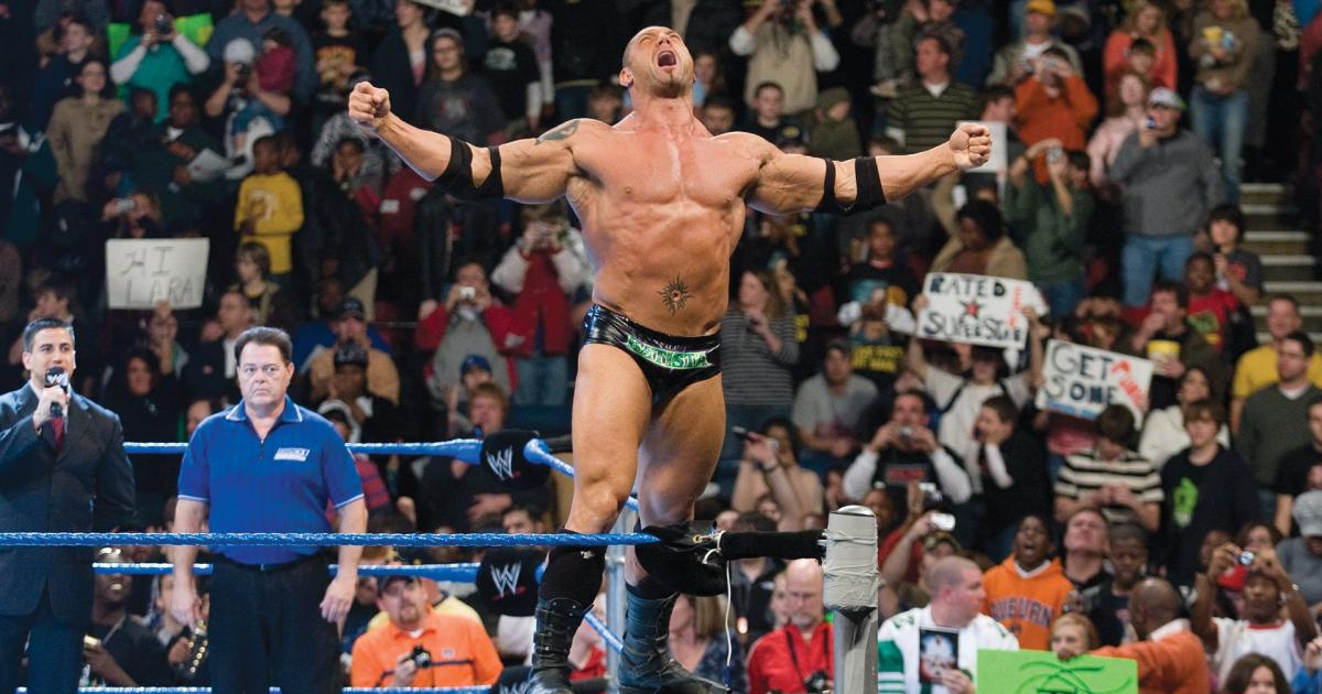 dave bautista è in piedi sulle corde del ring e urla verso il pubblico a braccia aperte - nerdface