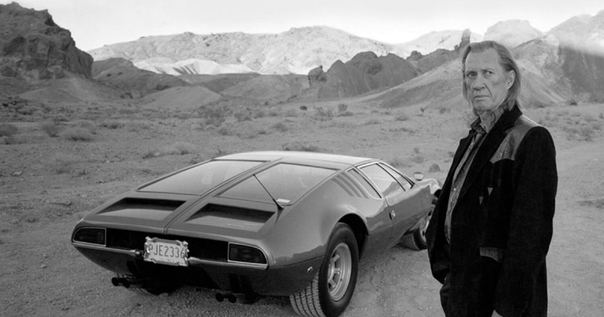 david carradine è in posa nel deserto accanto a un'auto sportiva - nerdface