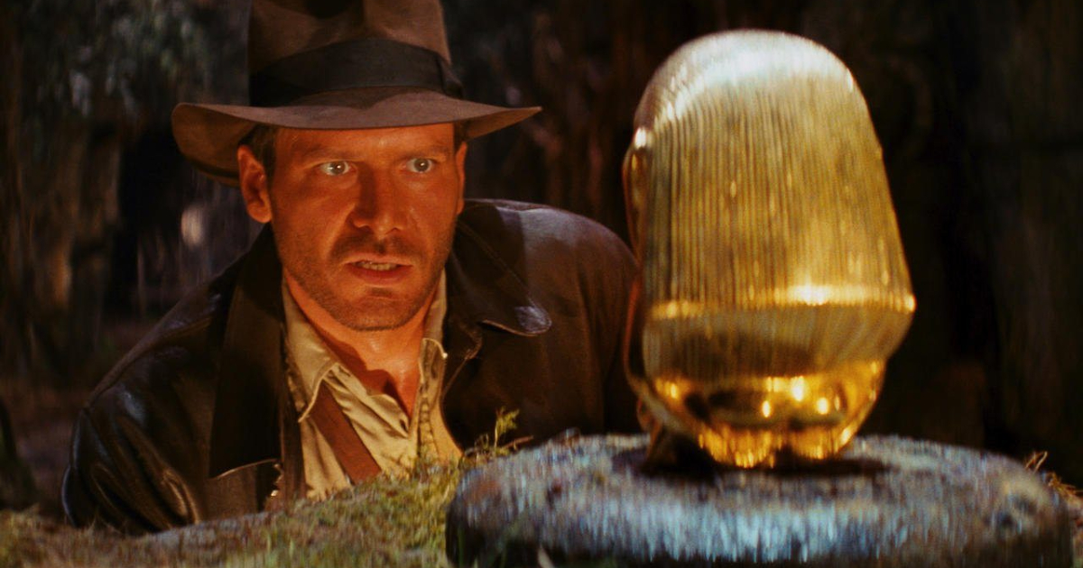 in indiana jones e i predatori dell'arca perduta harrison ford osserva un tesoro fatto in oro - nerdface