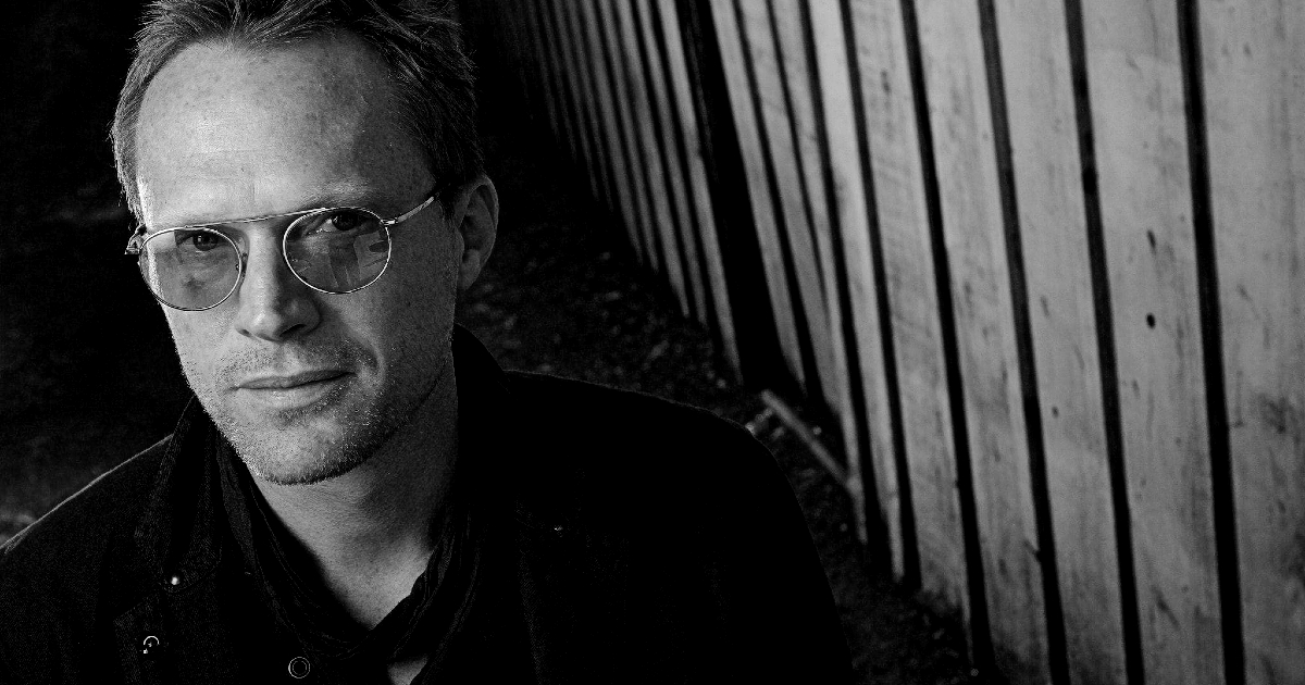 paul bettany sorride accanto a una parete di doghe verticali - nerdface