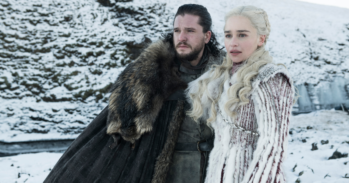 scena di Game of Thrones: Daenerys vestita di bianco e Jhon Snow nel suo classico mantelo del corvo, in mezzo alla neve