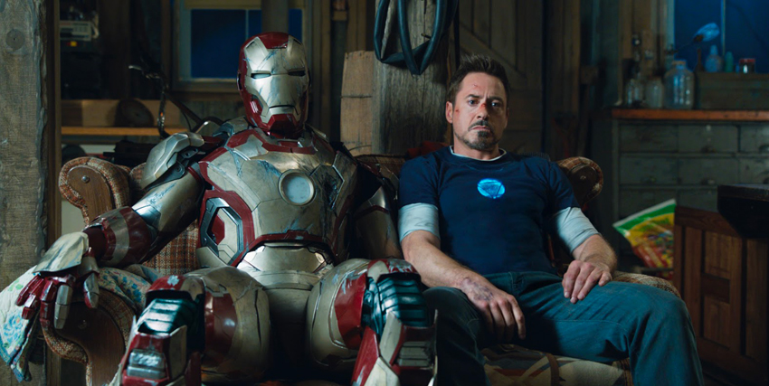 robert downey jr. seduto accanto all'armatura di iron man - nerdface