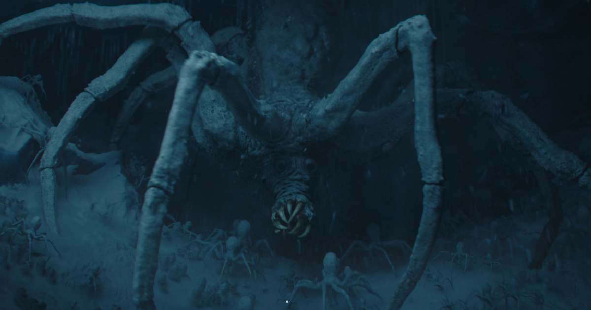 un enorme mostro simile a un ragno emerge dalle rocce - nerdface