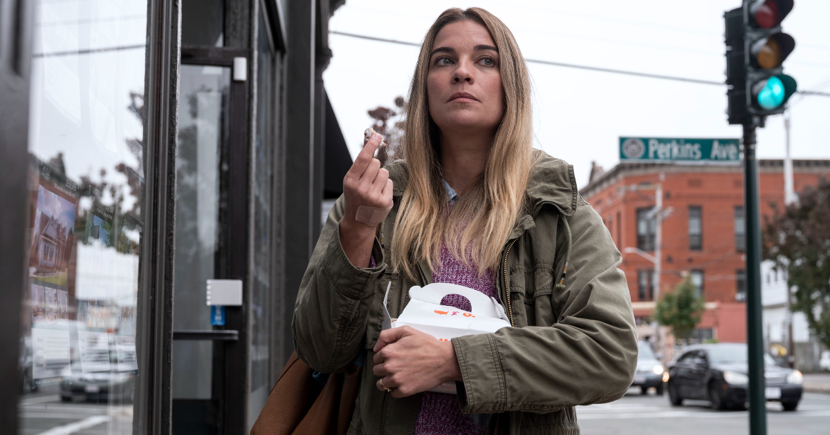 la protagonista cammina per strada e mangia alcuni pasticcini da una bag bianca di cartone - nerdface