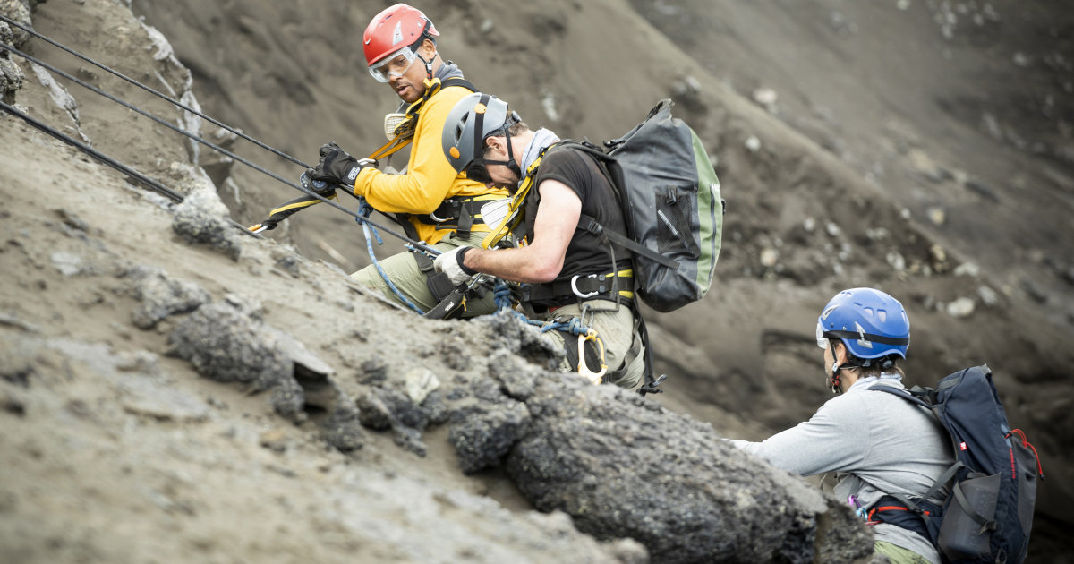 will smith imbracato e col caschetto rosso si arrampica sulla parete di una montagna - nerdface