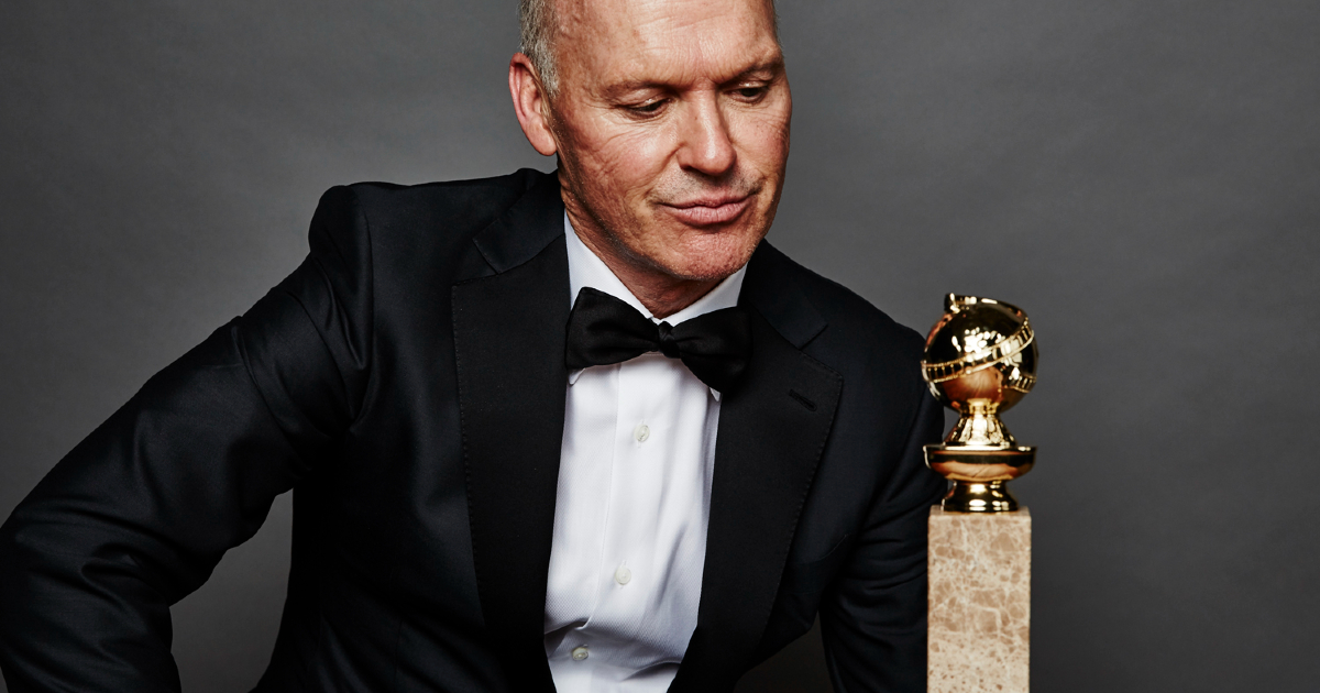 un buffo ritratto di michael keaton in smoking, mentre guarda un golden globe - nerdface