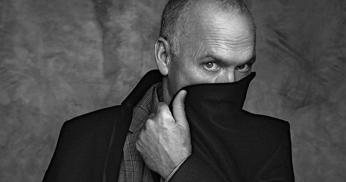 un curioso ritratto di michael keaton in bianco e nero mentre si copre metà volto col bavero del cappotto - nerdface