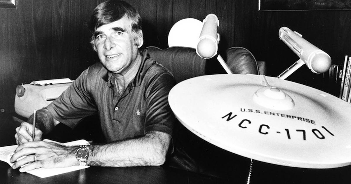 gene roddenberry in una celebre foto in cui siede alla sua scrivania accanto a un modello gigaqnte dell'enterprise xhe tutti vorremmo avere - nerdface