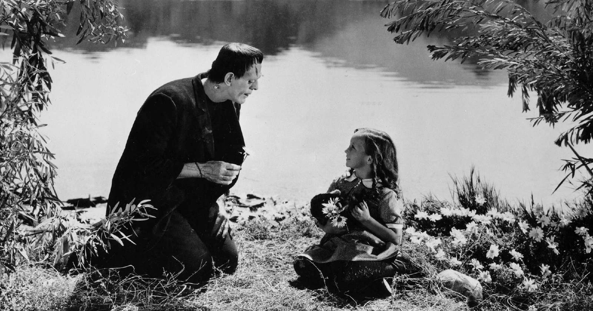 la creatura di frankenstein e una bambina parlano in riva a un lago - nerdface