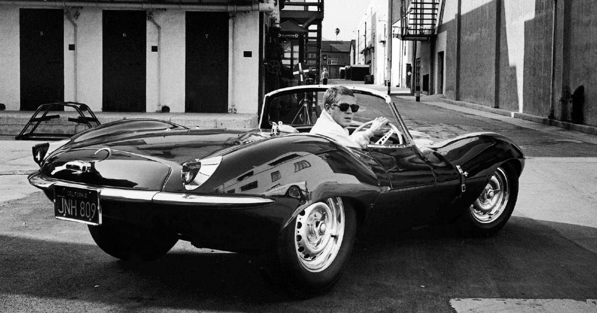 steve mcqueen si volta mentre è alla guida di una jaguar spider - nerdface