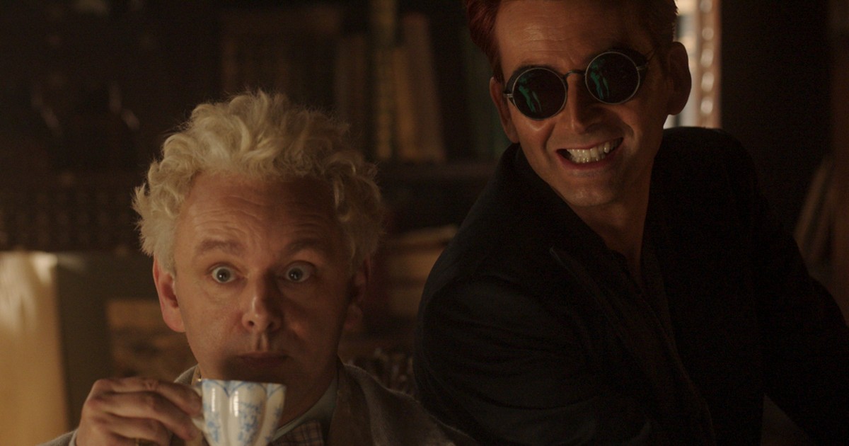 Aziraphale beve una tazza di tè con a fianco Crowley - nerdface