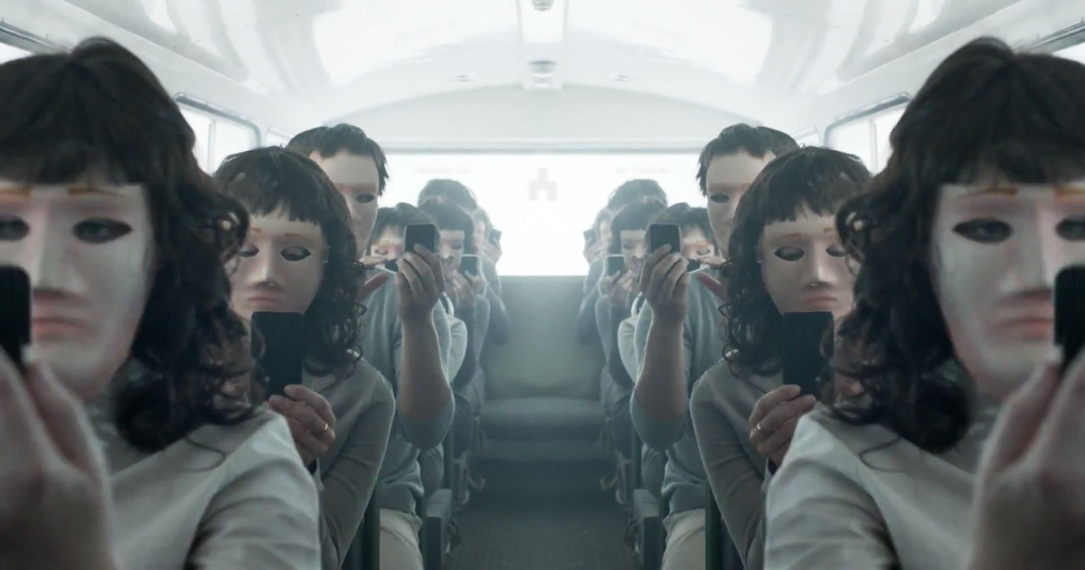 un gruppo di uomini e donne in un pullman indossa una maschera senza lineamenti e guarda al cellulare in black mirror - nerdface