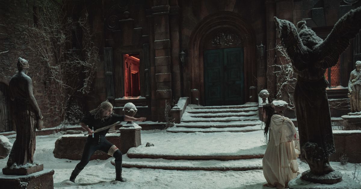 geralt combatte una donna vestita di bianco davanti un tempio in the witcher - nerdface