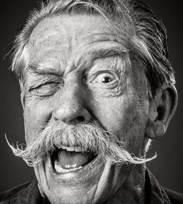 john hurt fa un'espressione buffa chiudendo un occhio e storcendo la bocca - nerdface