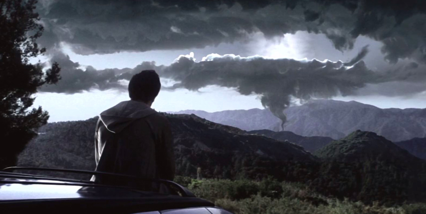 donnie darko seduto sul cofano di una macchina guarda il cielo nuvoloso - nerdface