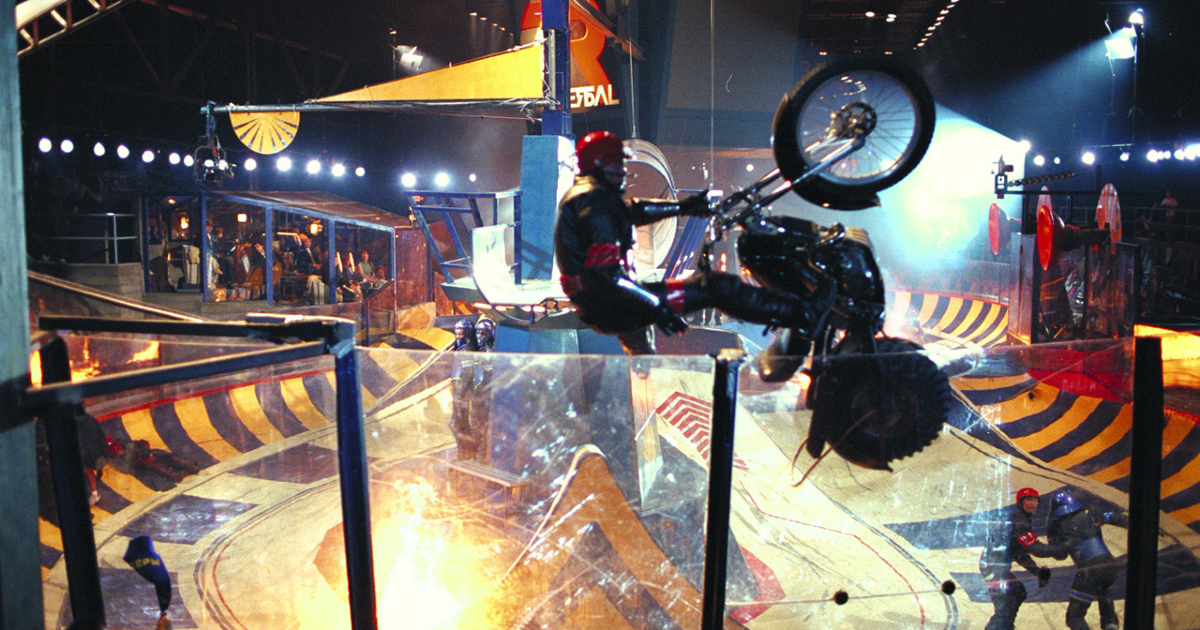 una moto fa un'acrobazioa sulla pista di rollerball, il remake firmato da john mctiernan - nerdface