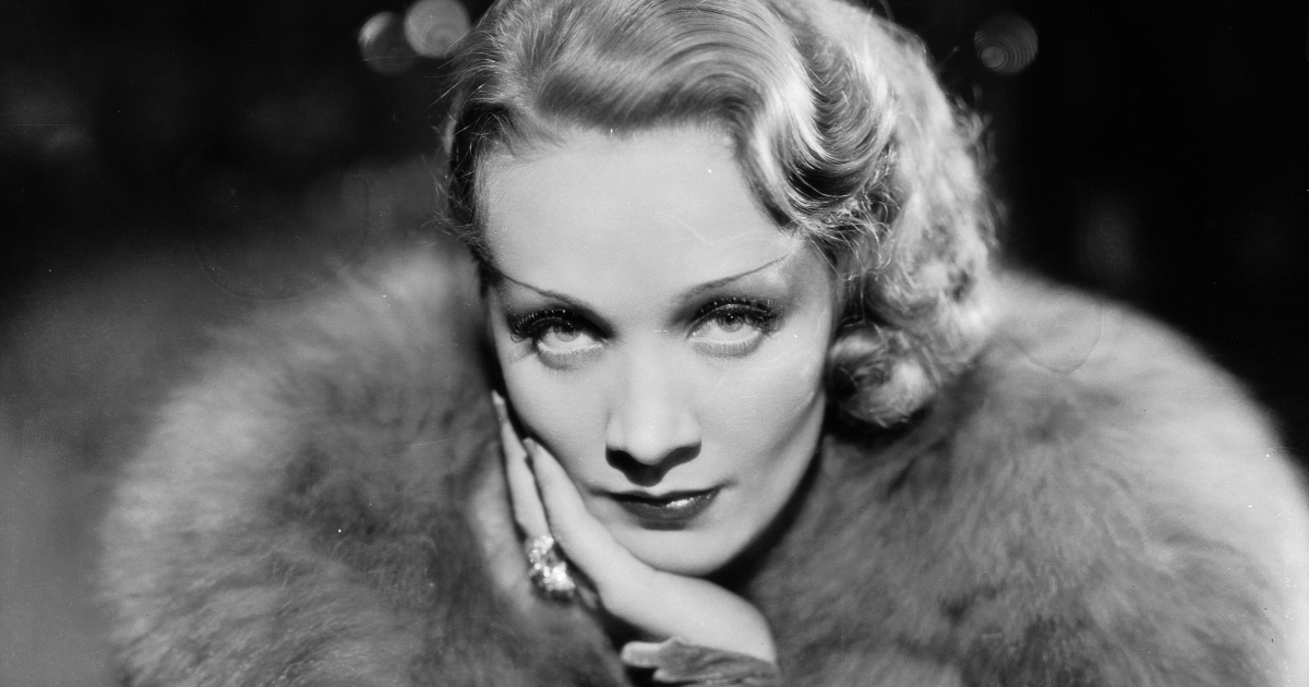 marlene dietrich si tiene il mento con una mano e indossa una pelliccia - nerdface