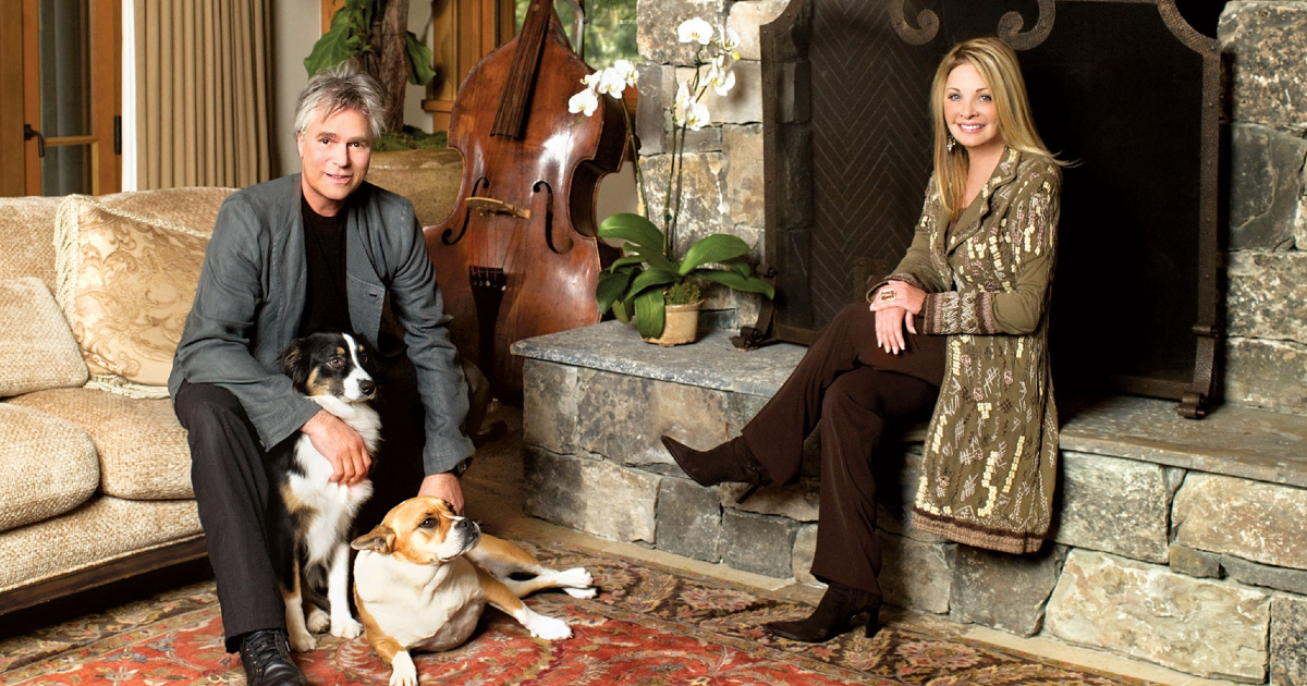 richard dean anderson con sua moglie e i suoi due cani in un salotto davanti il camino - nerdface