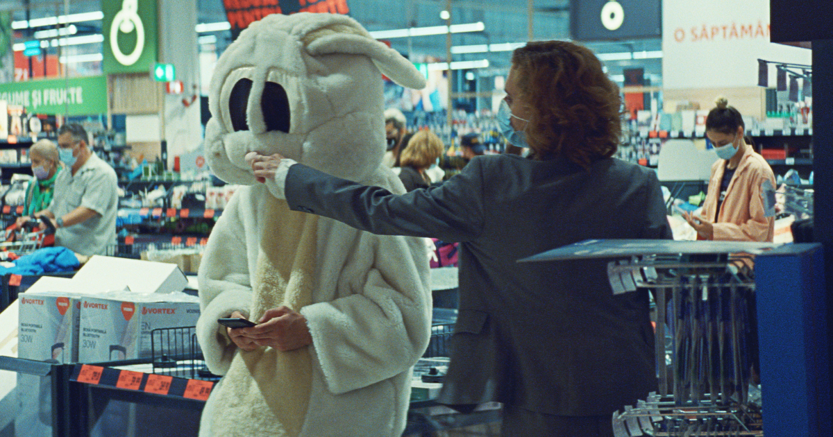 la protagonista in un supermercato imbocca un uomo vestito da coniglio - nerdface