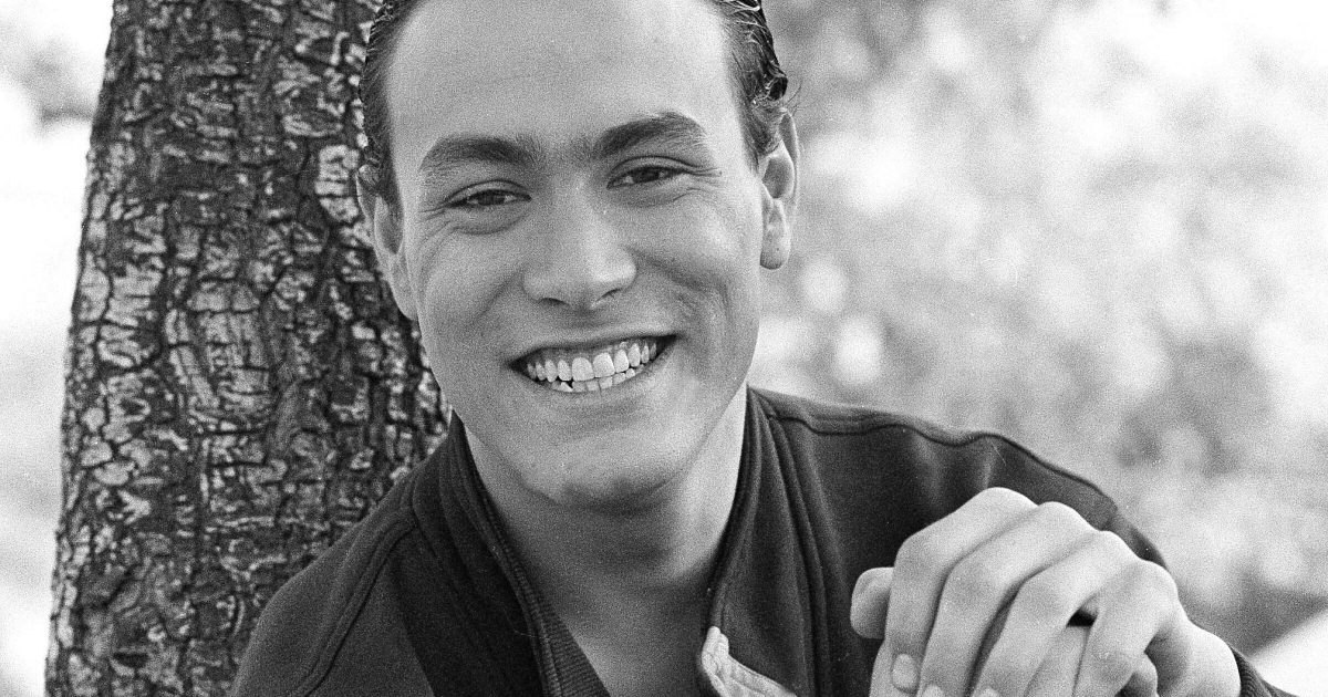 brandon lee è poggiato su un albero e sorride - nerdface