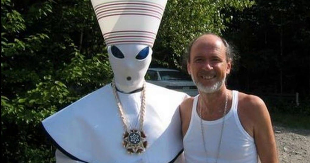 un tizio pelato e in canotta bianca sorride insieme a un altro vestito dalieno in divisa da sacerdote egizio: na roba incredibile - nerdface