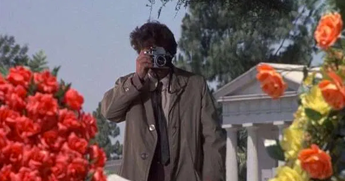 peter falk fa alcune foto dietro due siepi di fiori - nerdface