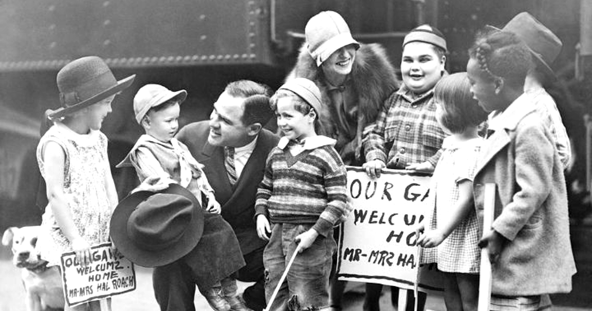 hal roach circondato dai bambini, davanti un treno - nerdface