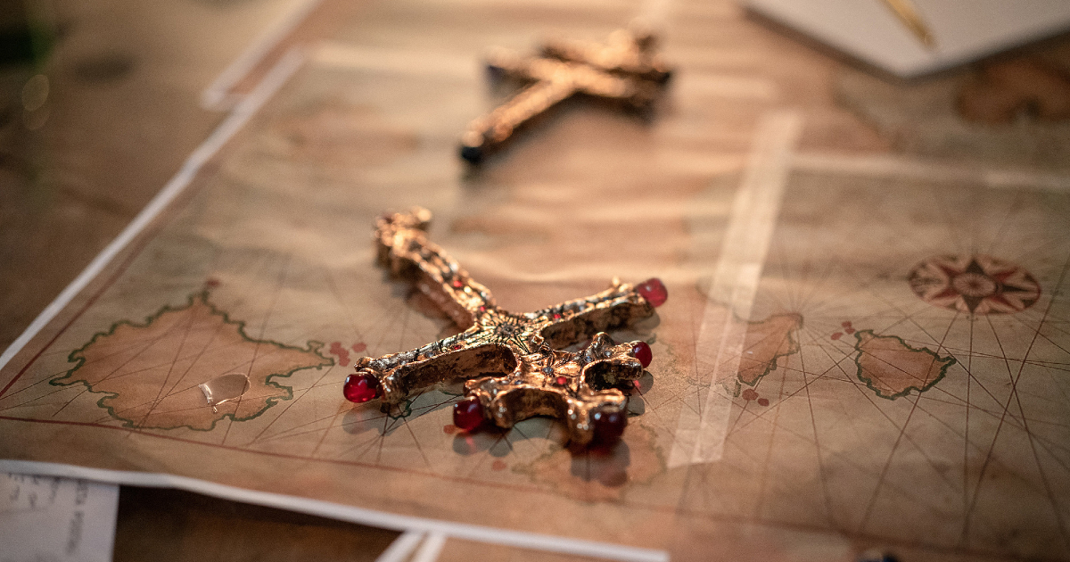 due grosse croci dorate sono posate una carta geografiche: sono le chiavi del tesoro di uncharted? - nerdface