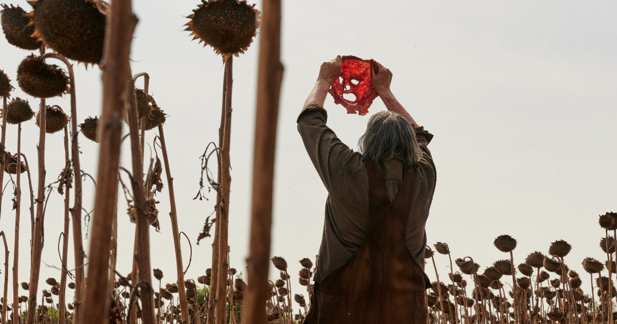 leatherface solleva verso il cielo la maschera di pelle umana appena scuoiata dal volto di qualcuno - nerdface