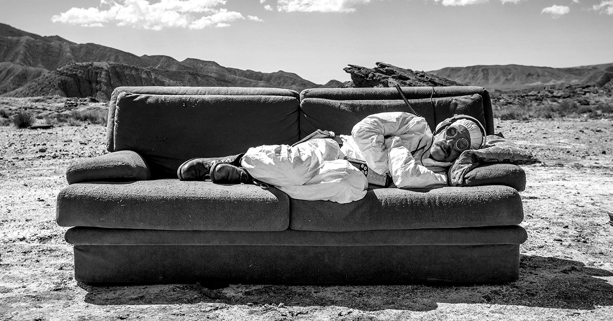 valerio mastandrea in tuta antiradiazioni dorme su un divano in mezzo al deserto - nerdface