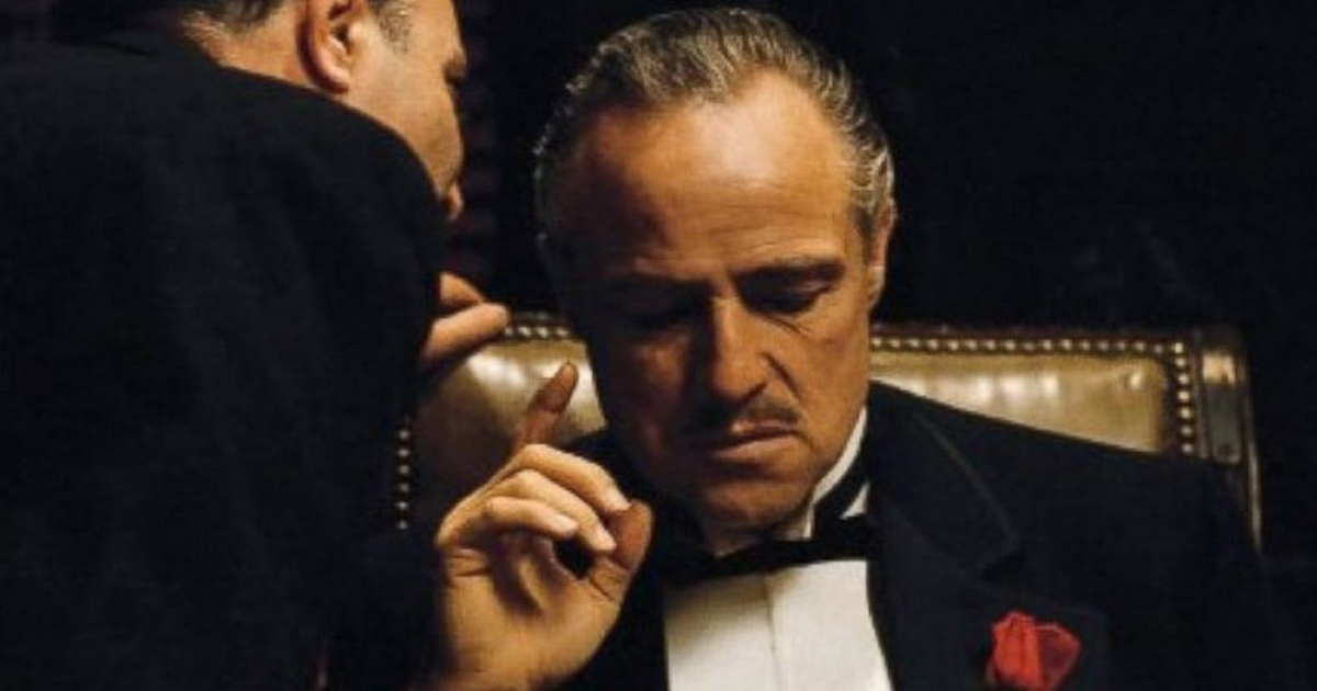 marlon brando è il padrino e ascolta un aiutante che gli dice qualcosa all'orecchio - nerdface