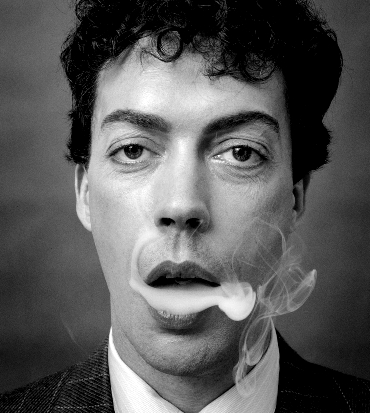 un giovane tim curry sbuffa il fumo di una sigaretta - nerdface