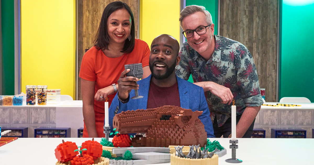 alcuni concorrenti di lego masters uk banchettano davanti ad una testa di maiale fatta di lego - nerdface