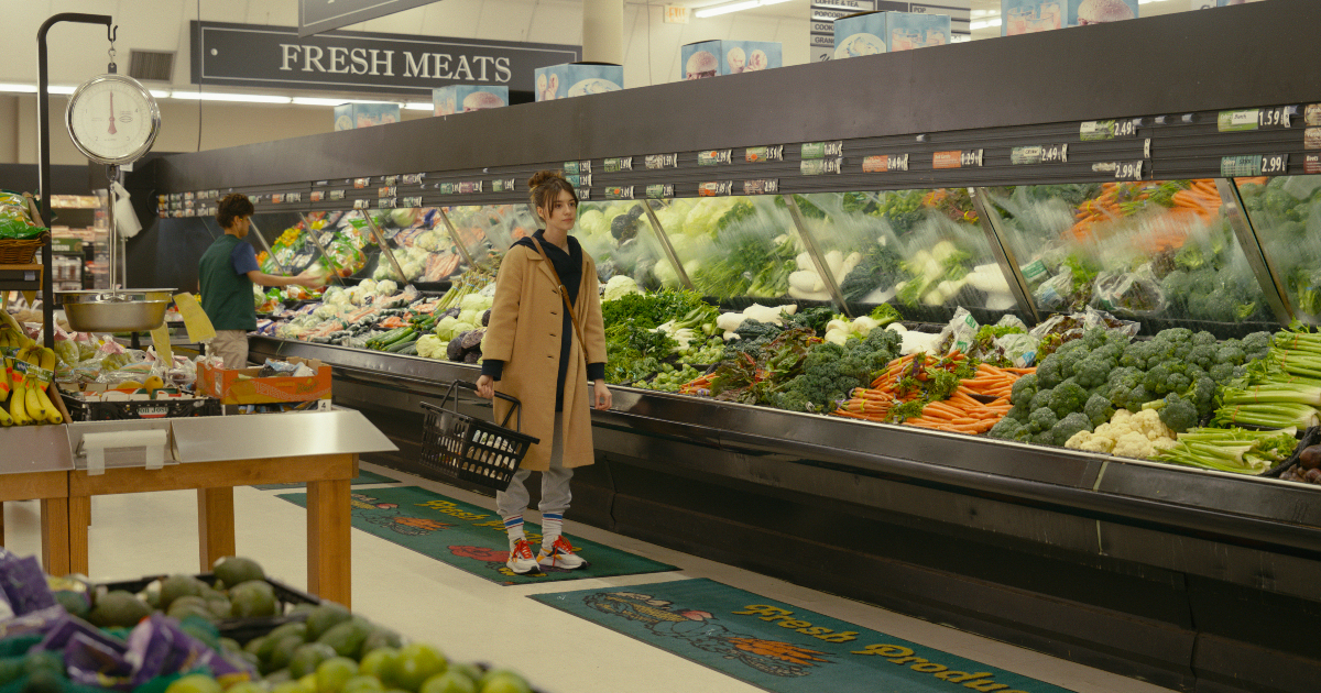 una donna cammina nel reparto verdura di un supermercato - nerdface