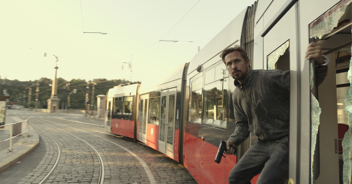 ryan gosling si affaccia da un tram e impugna una pistola - nerdface