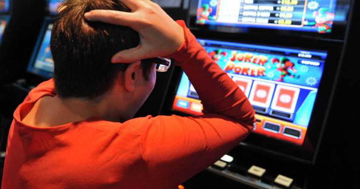 un ragazzo di fronte alle slot si tiene la testa e sembra disperato - nerdface