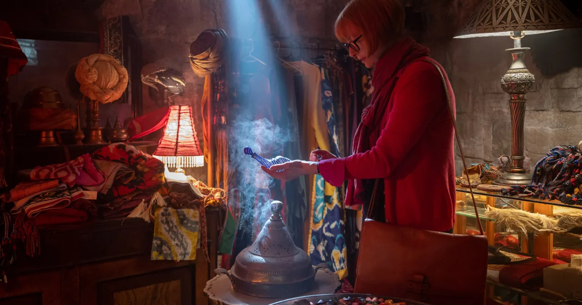 una donna esamina la lampada al bazar - nerdface