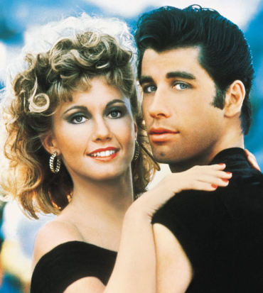 i due protagonisti di grease sorridono in camera - nerdface