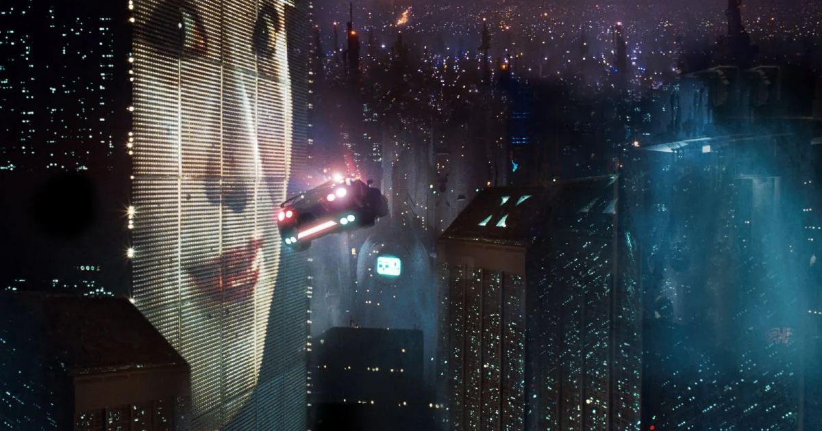 la celebre immagine di blaqde runner in cui un'auto volante passa accanto a un grattacielo con un enorme volto di donna orientale sulla facciata - nerdface