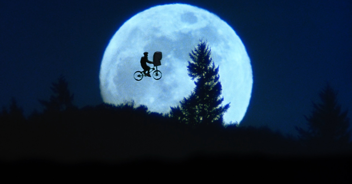 la celebre immagine di e.t. l'extraterrestre in cui il bambino vola con la bmx e l'alieno nella cesta davanti la luna piena - nerdface