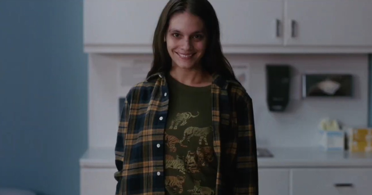 una ragazza sorride in maniera inquietante in una scena del trailer di smile - nerdface